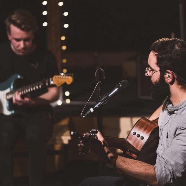 Zwei Männer mit Gitarren die Lobpreis machen.